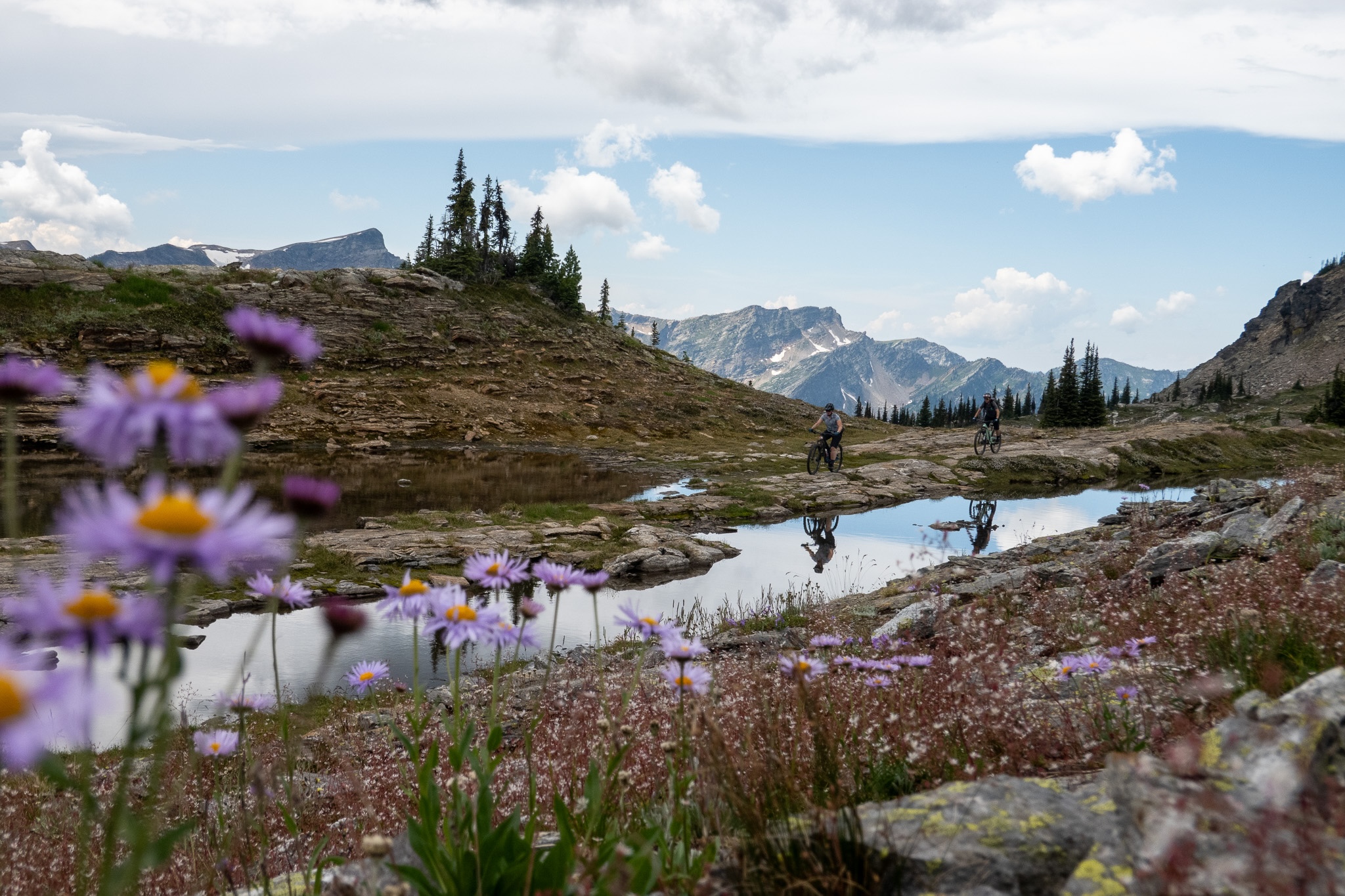 women mountain biking near an alpine lake in the mountains